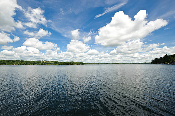 istock White Clouds in blue sky over calm lake 151509994