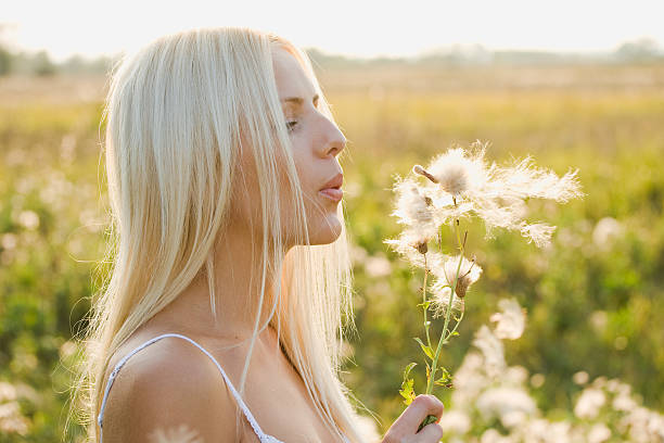istock Pretty woman is blowing dandelion 151510610