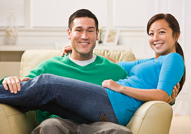 istock Attractive Smiling Couple on Sofa 151510737
