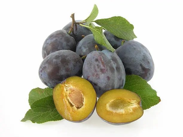 plums with cut-up halves and leaves