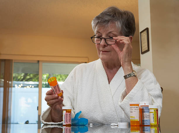 istock Woman reading medication bottle 151513037