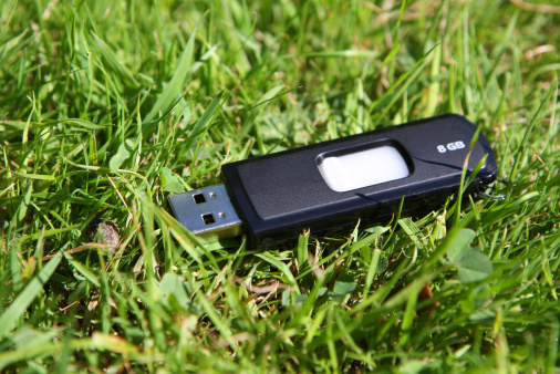 USB flash drive in grass representing lost data