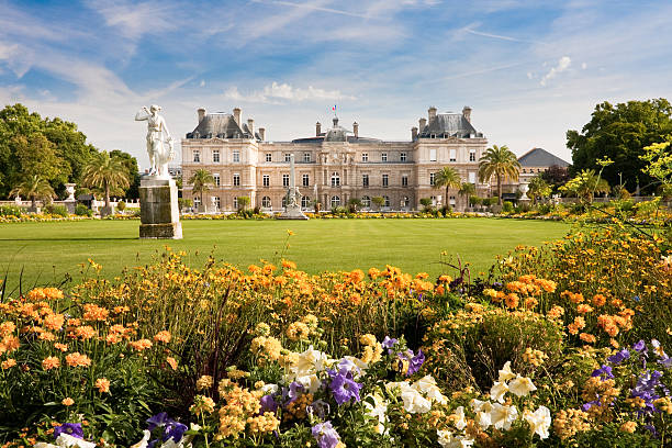 Luxembourg Palace with flowers Jardin du Luxembourg with the Palace and statue. Few flowers are in front and blue sky behind. luxembourg paris stock pictures, royalty-free photos & images