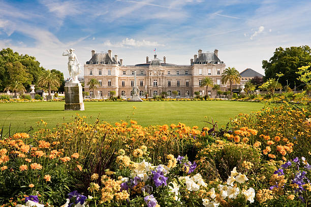 Luxembourg Palace with flowers Jardin du Luxembourg with the Palace and statue. Few flowers are in front and blue sky behind. luxemburg stock pictures, royalty-free photos & images