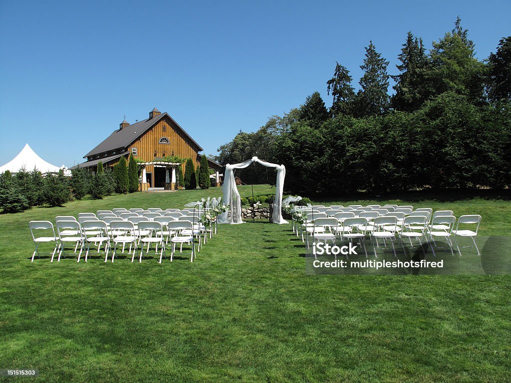Perfect outdoor wedding scene A perfect location setup for an outdoor wedding. Chairs setup and simple area for bride and groom, barn in background. Wedding Stock Photo