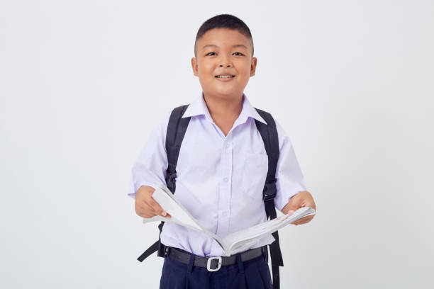 istock A young Asian cute boy standing in a Thai school uniform with a backpack bag and book on a white background banner. Back to school 1515157240