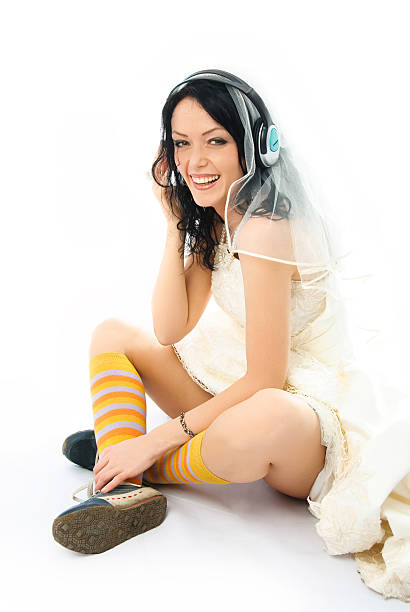 happy bride wearing earphones and sporting shoes stock photo