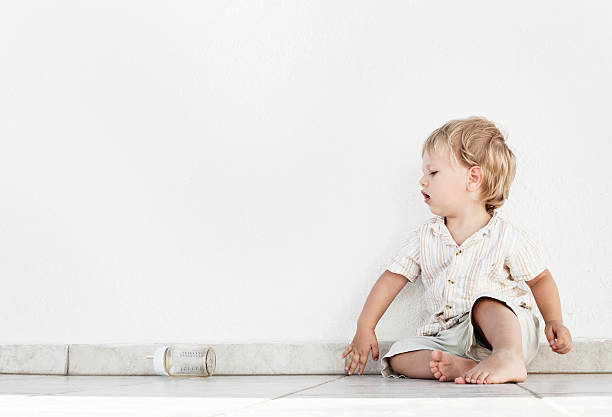 istock little boy sitting with his bottle 151516185