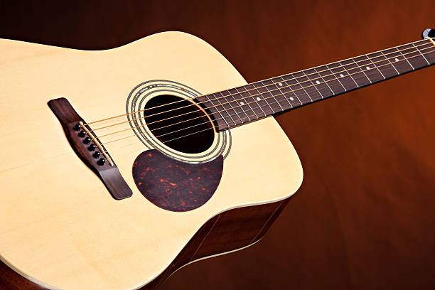 istock Acoustic Guitar Isolated on Gold 151516526
