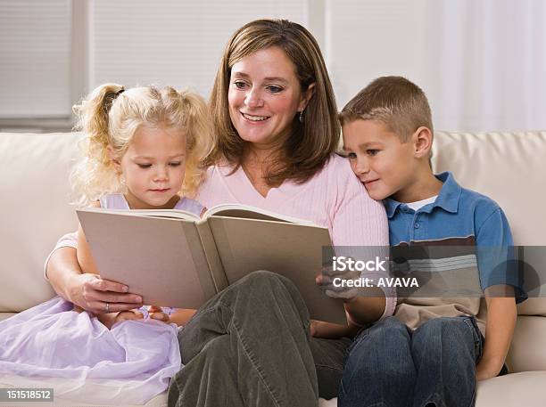 Happy Mother Reading To Children Stock Photo - Download Image Now - Adult, Affectionate, Apartment