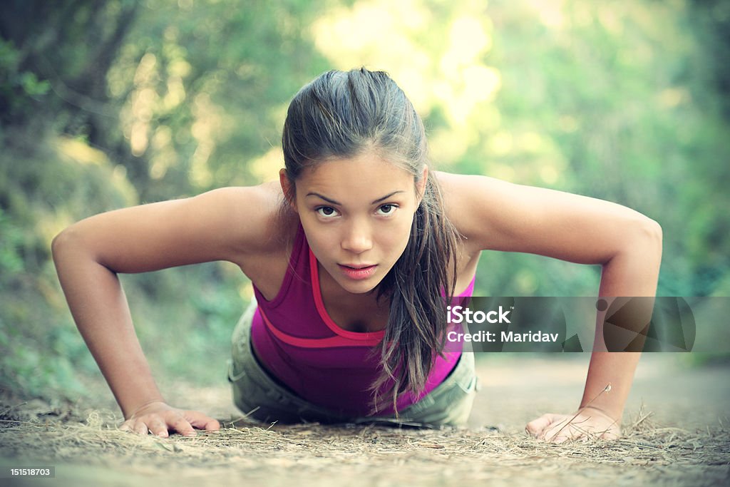 Exercise woman training doing push-ups outside Exercise woman doing push-ups outdoors in the forest, Beautiful young female athlete. For more: 20-29 Years Stock Photo