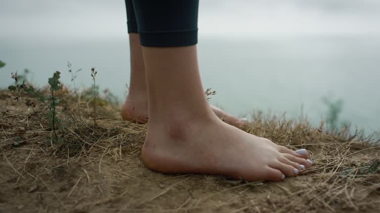 Bare legs unknown woman going on sandy hill close up. Girl stop at hilltop.