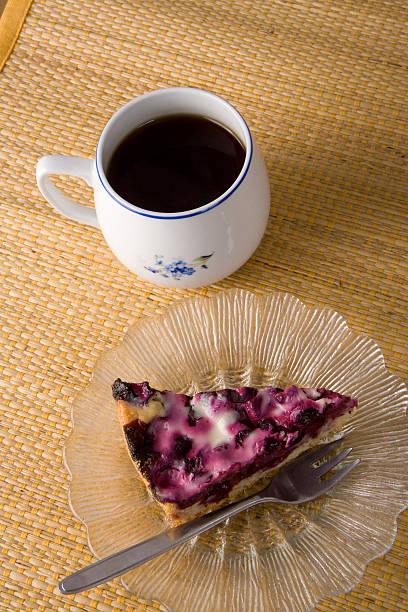 Placek z jagodami na talerzu z herbaty i Widelec – zdjęcie