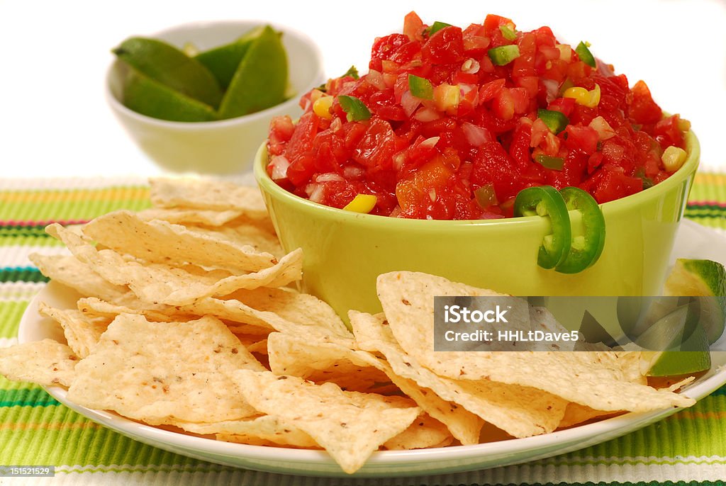 Tortilla chips with salsa and lime Freshly made tortilla chips with a corn and tomatoe salsa with limes Appetizer Stock Photo