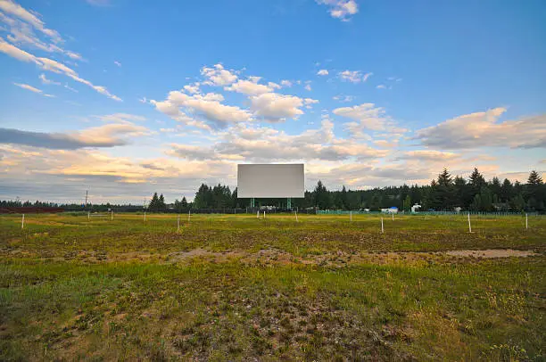Abandoned drive-in screen with sky and grass