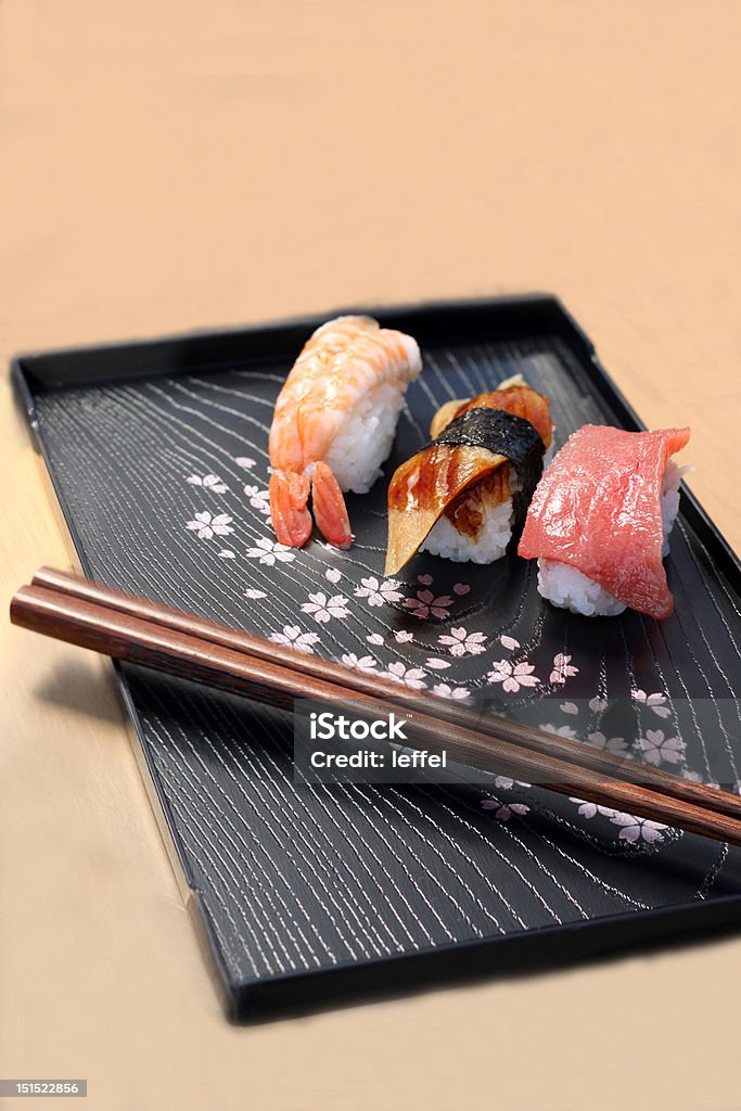 Tre pezzi di nigiri sushi con le Bacchette cinesi - Foto stock royalty-free di Alga marina