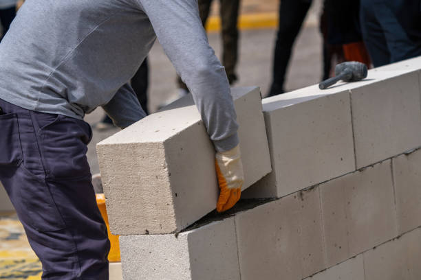 The bricklayer is working. Building a wall of aerated concrete. Gasbeton wall stock photo
