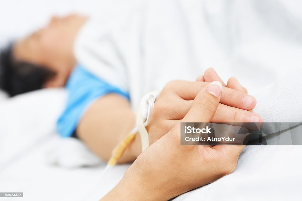 Holding patient hand in hospital Holding patient hand in hospital, showing care and love Affectionate Stock Photo