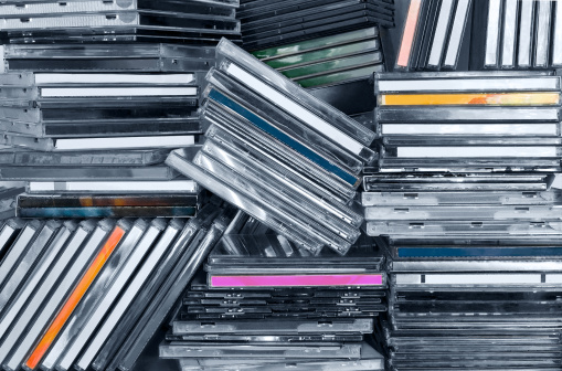 Piles of CDs in a shelf.