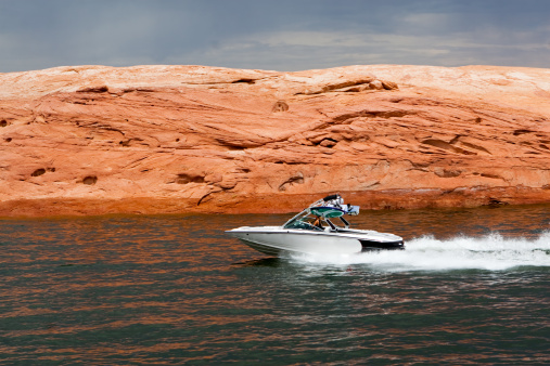 Speed boat zipping through the water at Lake Powell in Glen Canyon National Recreation Area, Utah