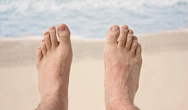 Man's feet on the beach stock photo