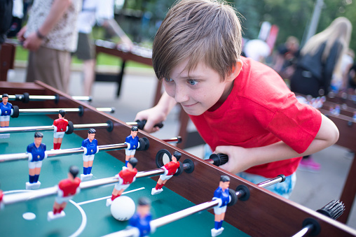 boy playing table football outside