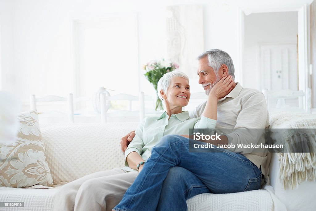 Happy romantic senior couple sitting on couch Senior Couple Stock Photo
