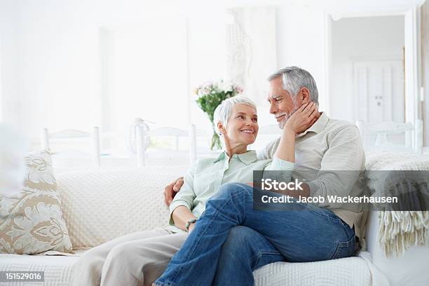 Happy Romantic Senior Couple Sitting On Couch Stock Photo - Download Image Now - Senior Couple, Domestic Life, Candid