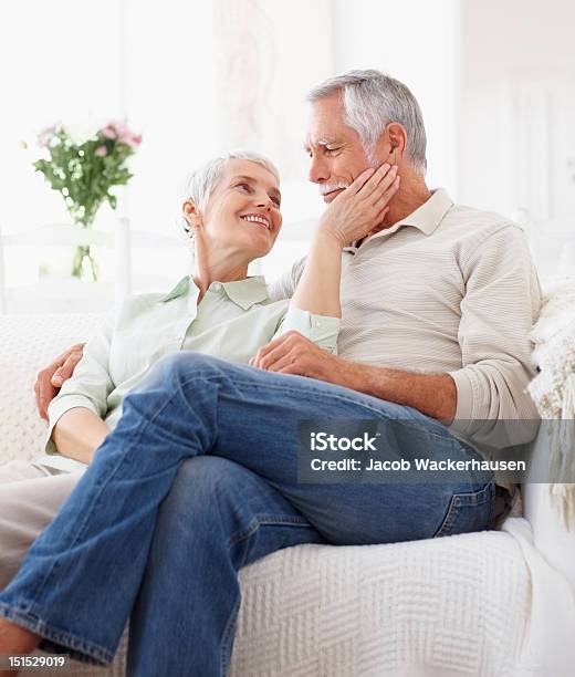 Felice Romantica Coppia Senior Seduto Sul Divano - Fotografie stock e altre immagini di Coppia anziana - Coppia anziana, Abbigliamento casual, Accogliente