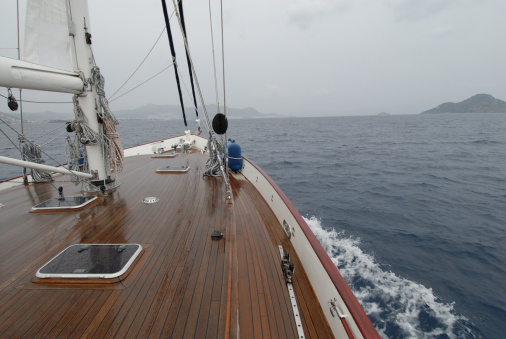 wooden sailboat sailing in the rain at the Mediterranean sea