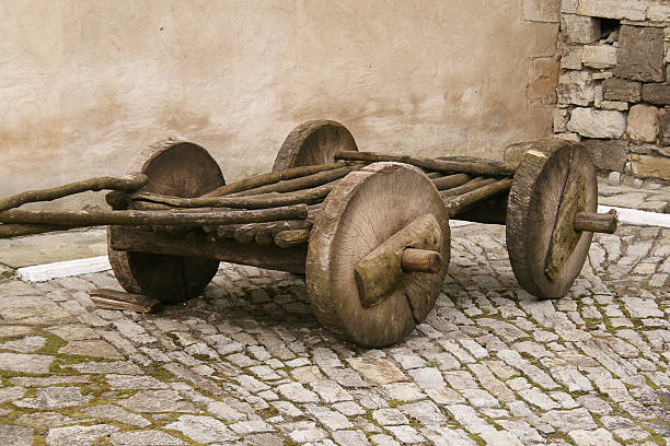 Ancient wooden cart on cobblestone path stock photo