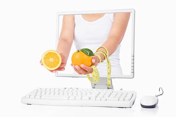 istock Female hand holding orange and measuring tape from computer 151531959