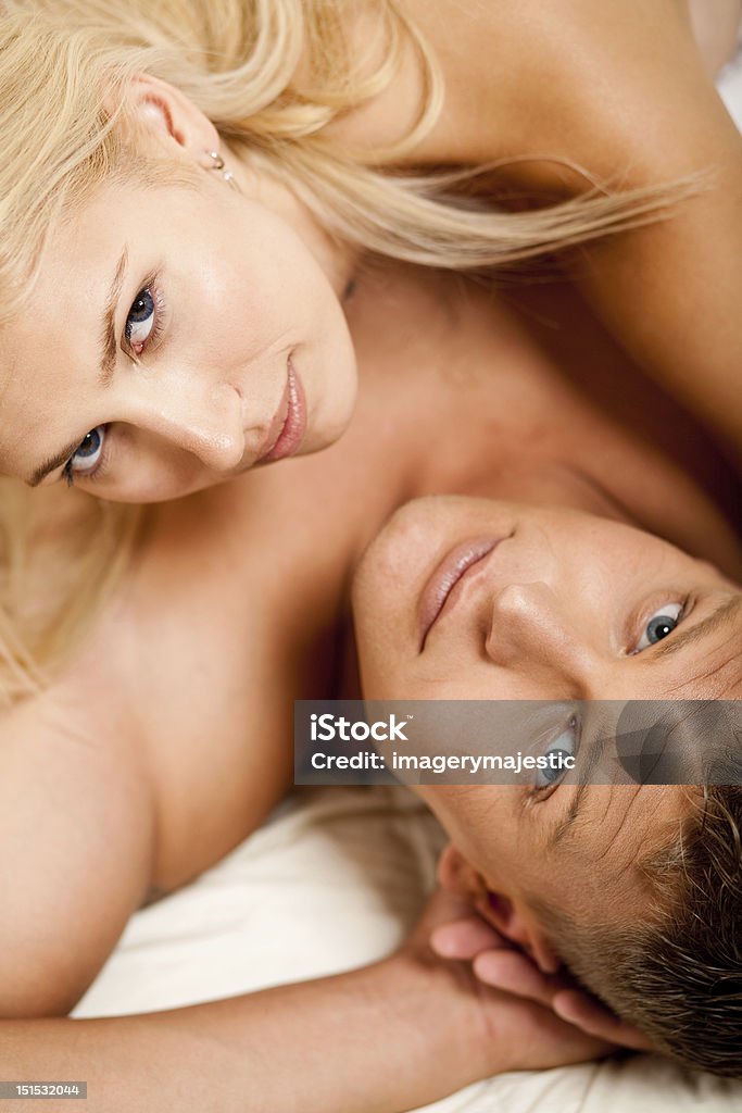 Ritratto di uomo e donna sdraiati a letto - Foto stock royalty-free di Accogliente