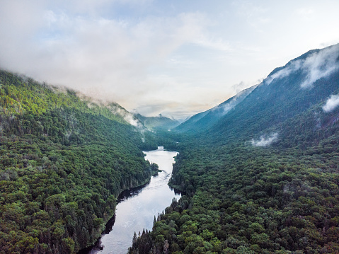 Aerial view of Jacques Cartier River in Quebec, Canada, during summer morning. There is fog and cloud in the mountain