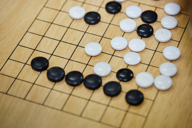 istock Putting baduk black stone on wooden grid board 1515335658