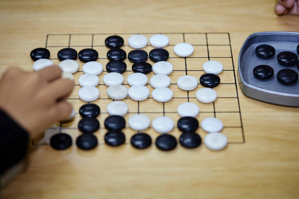 istock Putting baduk black stone on wooden grid board 1515335665