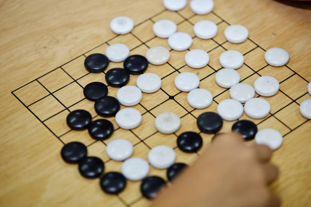 istock Putting baduk black stone on wooden grid board 1515335674