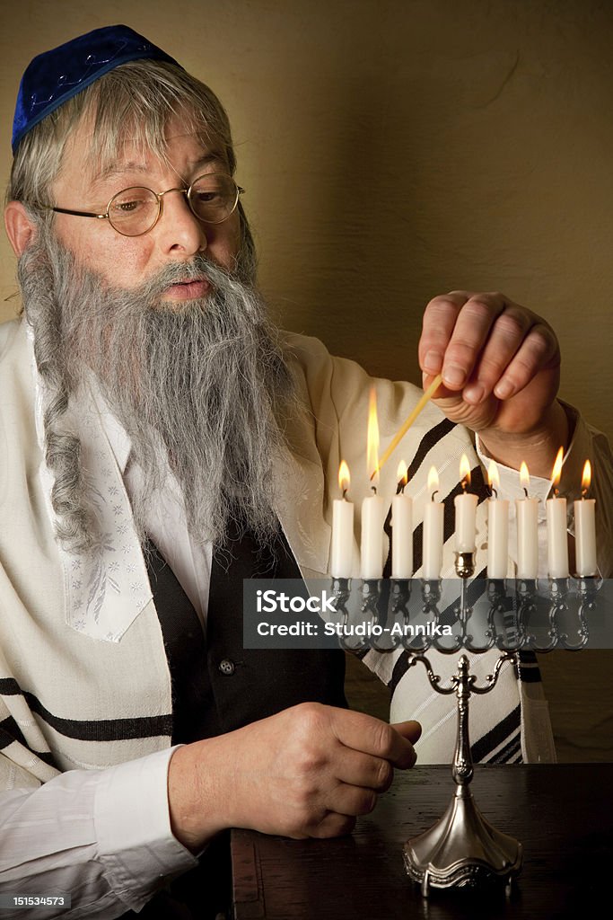 Hannukah candles Old jewish man lighting candles of a hannukah menorah Adult Stock Photo
