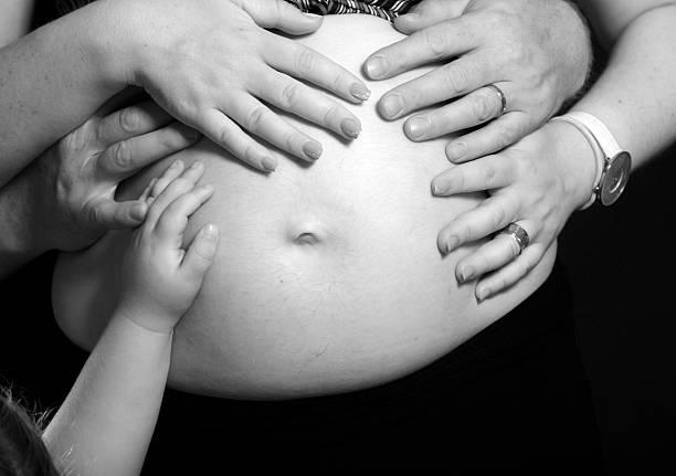 loving family hands hugging the pregnant stomach