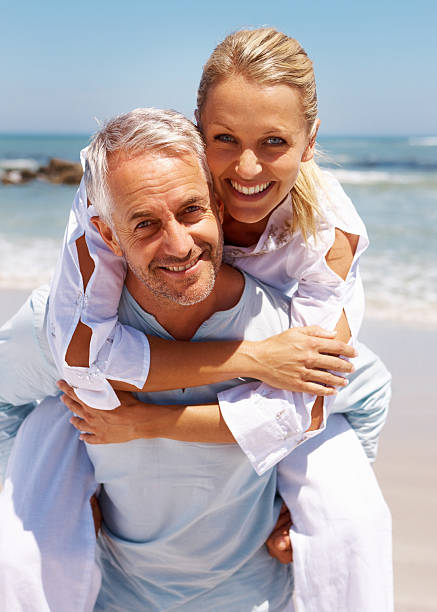 istock Man piggybacking his wife at beach 151535069