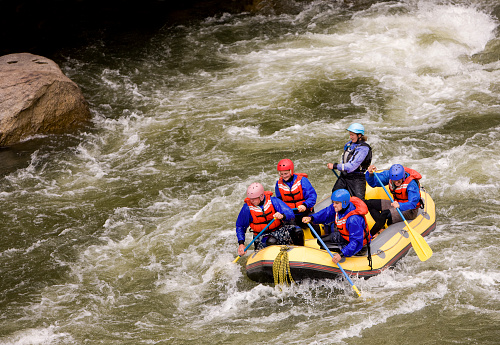 Group of four with guide white water rafting on Arkansas River in Colorado.