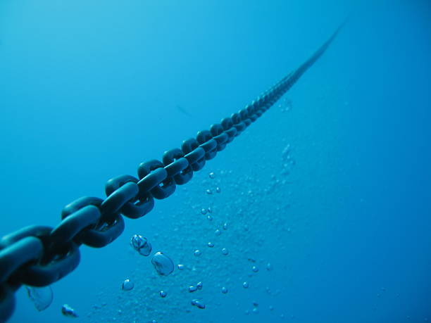 a chain from a boat dropped deep in to the ocean - demir zincir stok fotoğraflar ve resimler