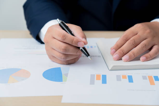 istock Business man analyzing financial document graph report paper 1515357767