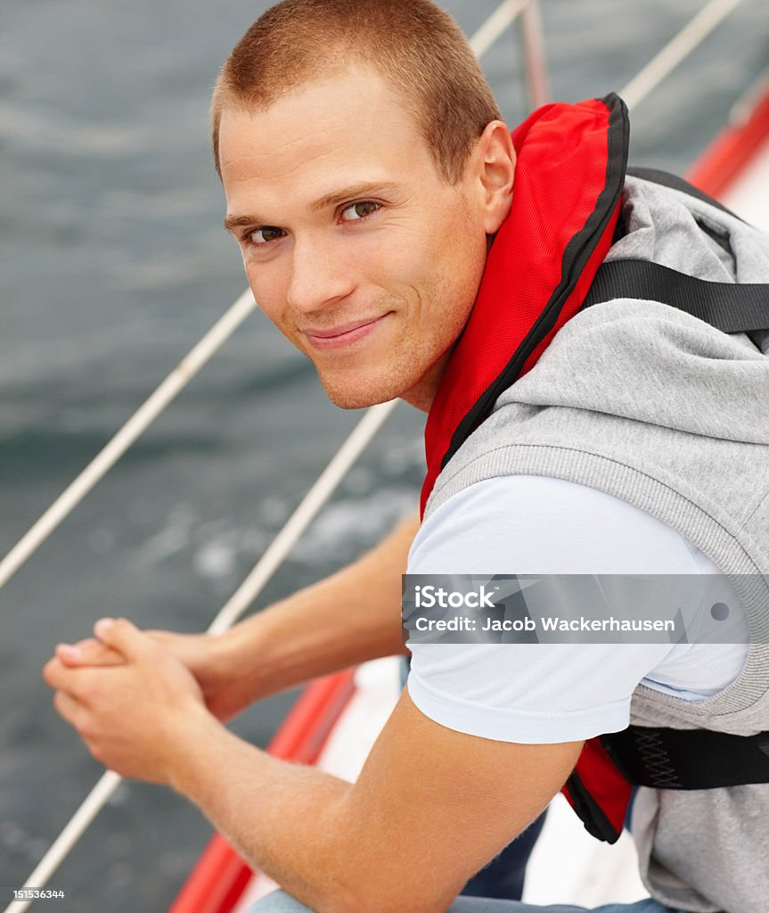 Felice giovane uomo in una barca - Foto stock royalty-free di Mezzo di trasporto marittimo