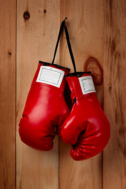 Hangin' em up A pair of red boxing gloves hangs from a nail weight class stock pictures, royalty-free photos & images