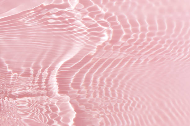istock Pink water with ripples on the surface. Defocus blurred transparent white colored clear calm water surface texture with splashes and bubbles. Water waves with shining pattern texture background. 1515382856