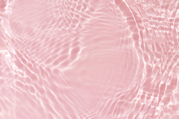 istock Pink water with ripples on the surface. Defocus blurred transparent white colored clear calm water surface texture with splashes and bubbles. Water waves with shining pattern texture background. 1515382872