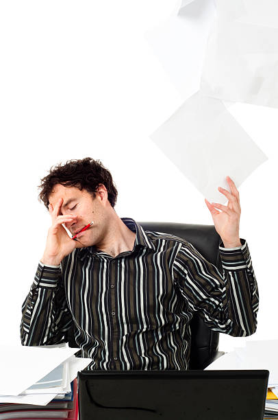 istock Man sitting at desk throwing up paperwork 151538541