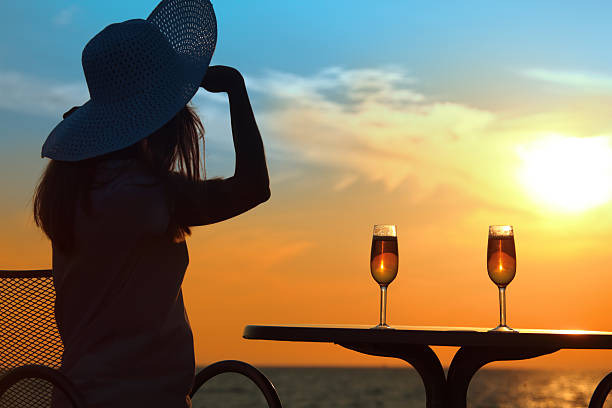 istock Female silhouette on sunset behind table with two glasses 151540880