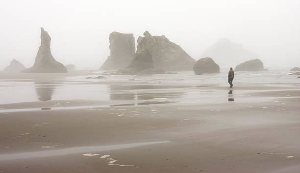 Man walking on Bandon deach stock photo